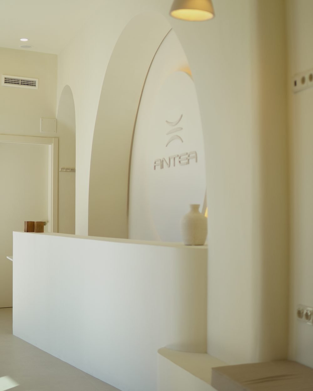 Recepción de Antea vista desde el pasillo, con el mostrador y el logotipo al fondo